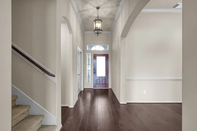 a view of a hallway with wooden floor and staircase