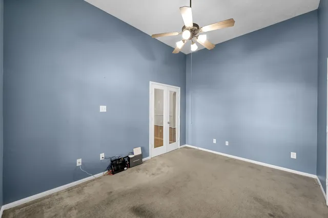 a view of an empty room with a chandelier fan