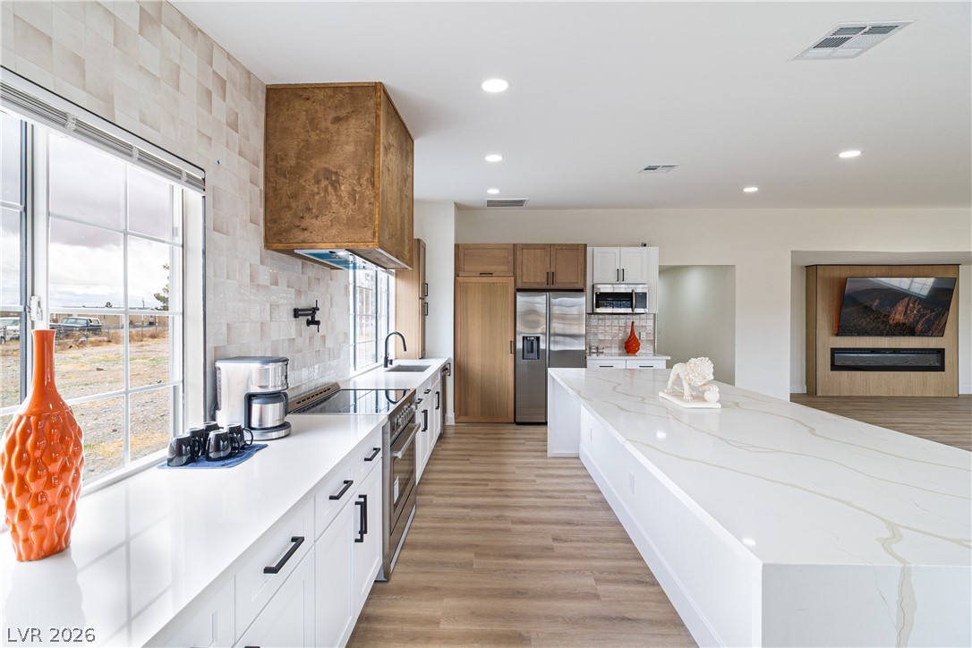 1891 Brian Road Pahrump, NV 89048 - Photo 1 of 50 Kitchen with tasteful backsplash, visible vents, appliances with stainless steel finishes, and light wood-type flooring