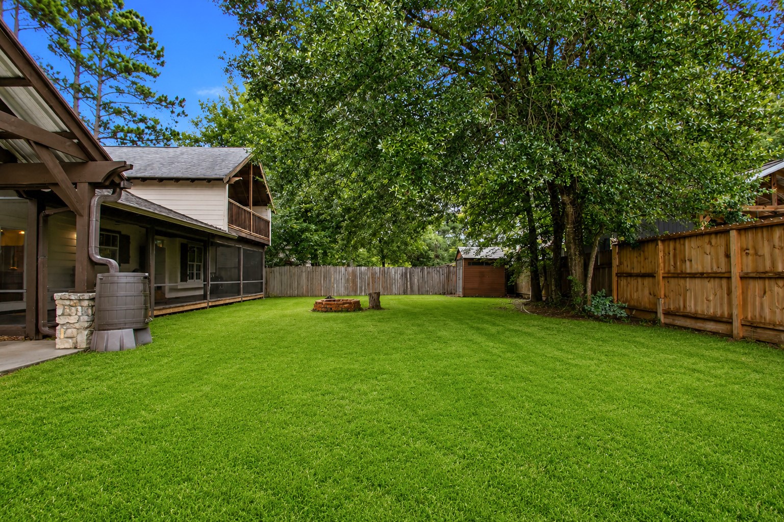 312 Springwood Drive Conroe, TX 77385 - Photo 48 of 50 Expansive backyard surrounded by mature trees for added privacy and outdoor enjoyment.