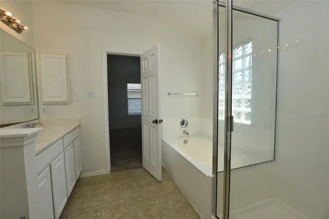 a bathroom with a tub sink and mirror