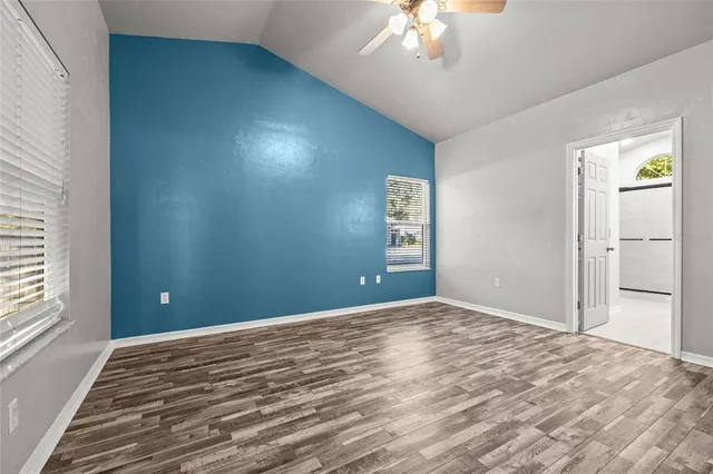 a view of a livingroom with a chandelier fan and windows