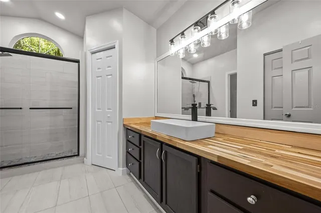 a bathroom with a sink a large mirror and a shower