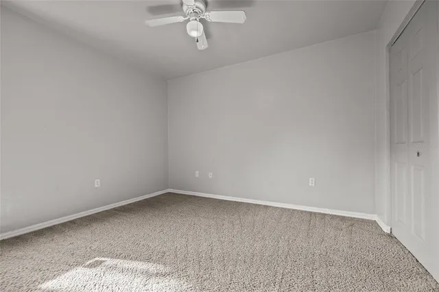 an empty room with a chandelier fan