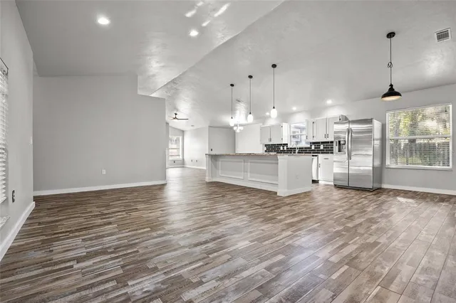 a view of a kitchen with furniture and wooden floor