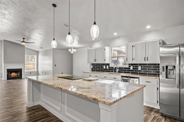 a kitchen with stainless steel appliances granite countertop a sink a stove and kitchen island