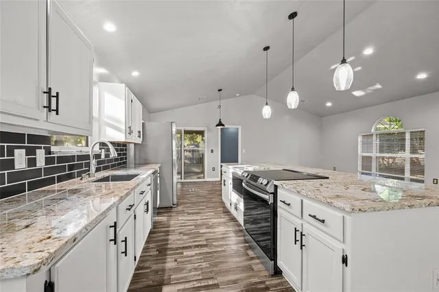 a kitchen with stainless steel appliances granite countertop a stove oven and a large kitchen island