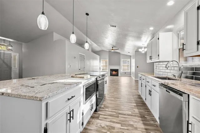 a large kitchen with stainless steel appliances lots of counter space and wooden floor