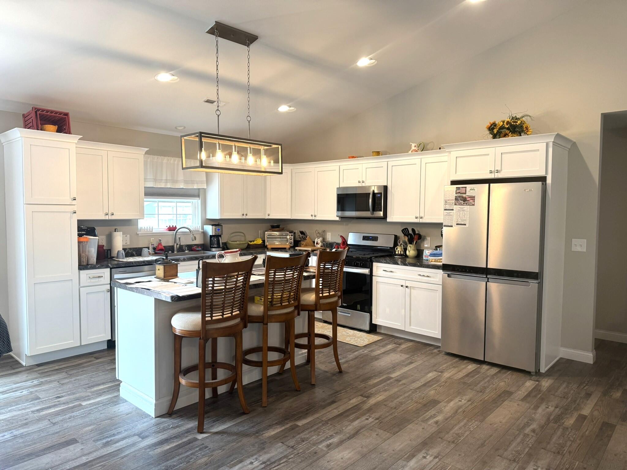 925 6th Avenue Northwest De Motte, IN 46310 - Photo 11 of 22 a kitchen with refrigerator cabinets dining table and chairs