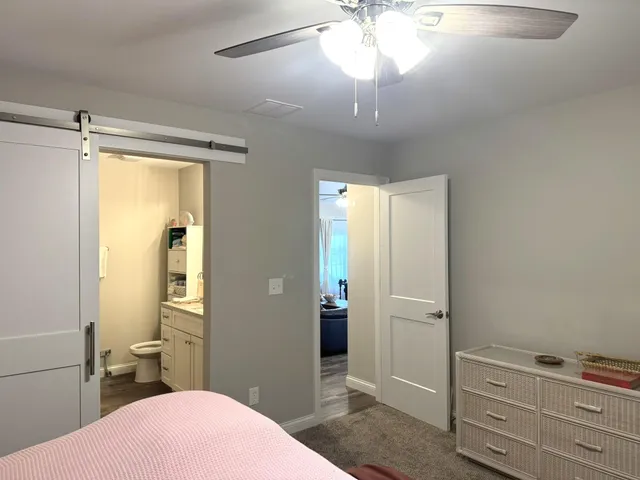 a bathroom with a granite countertop toilet a sink and a mirror