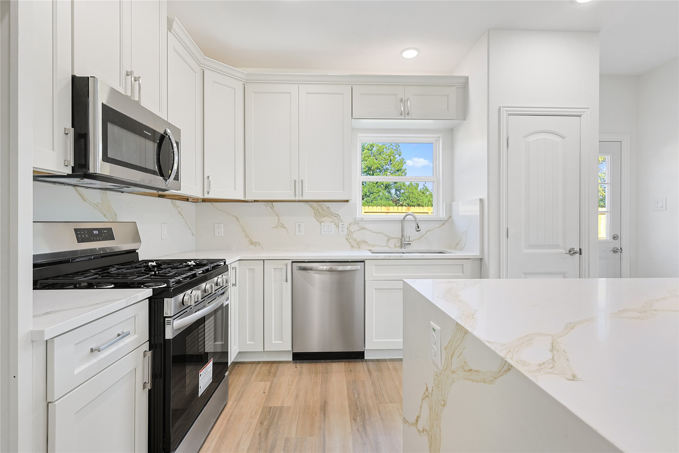 2317 Cedar Street Pearland, TX 77581 - Photo 13 of 33 a kitchen with granite countertop white cabinets and white appliances
