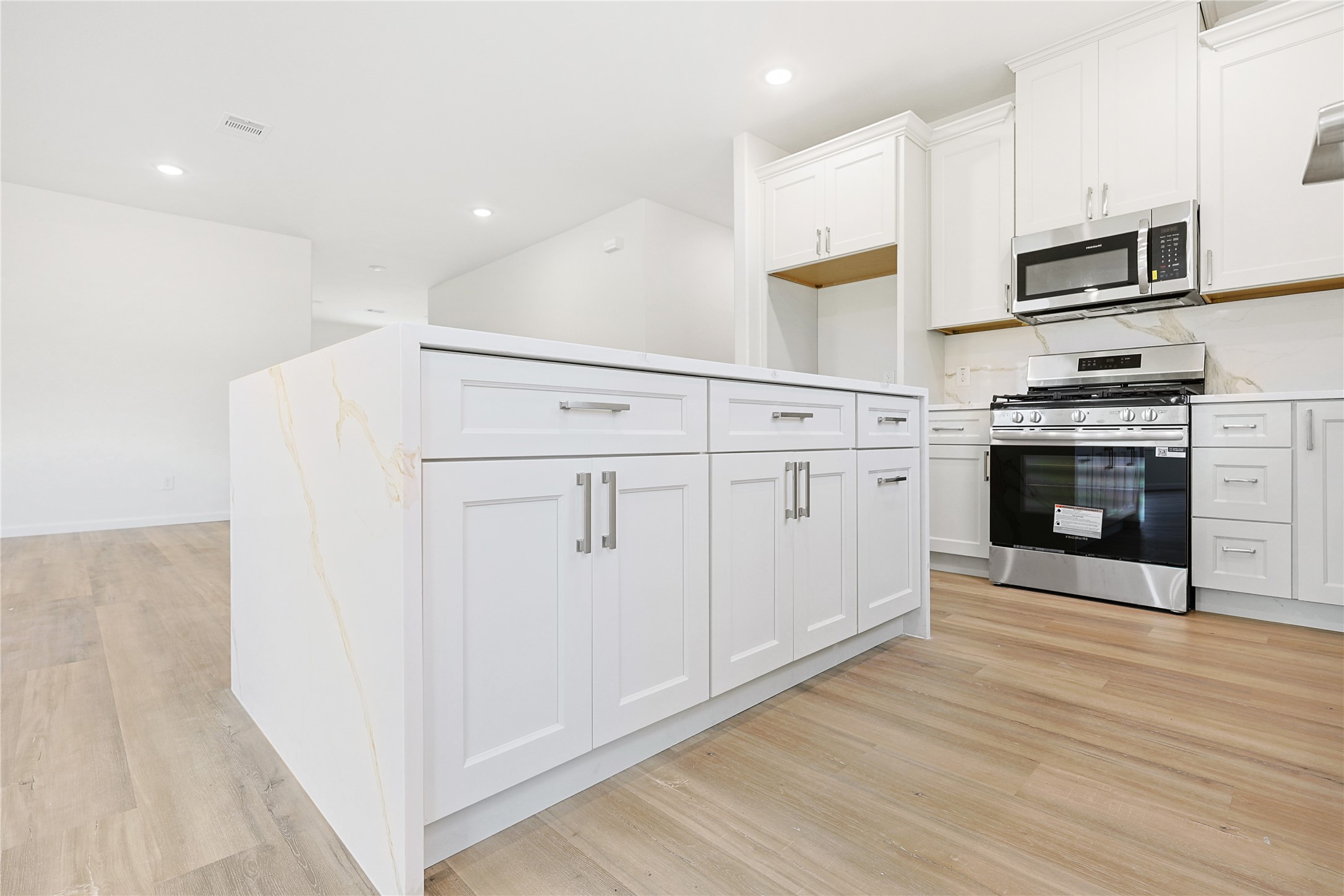 2317 Cedar Street Pearland, TX 77581 - Photo 16 of 33 a kitchen with stainless steel appliances granite countertop a stove a microwave and a refrigerator