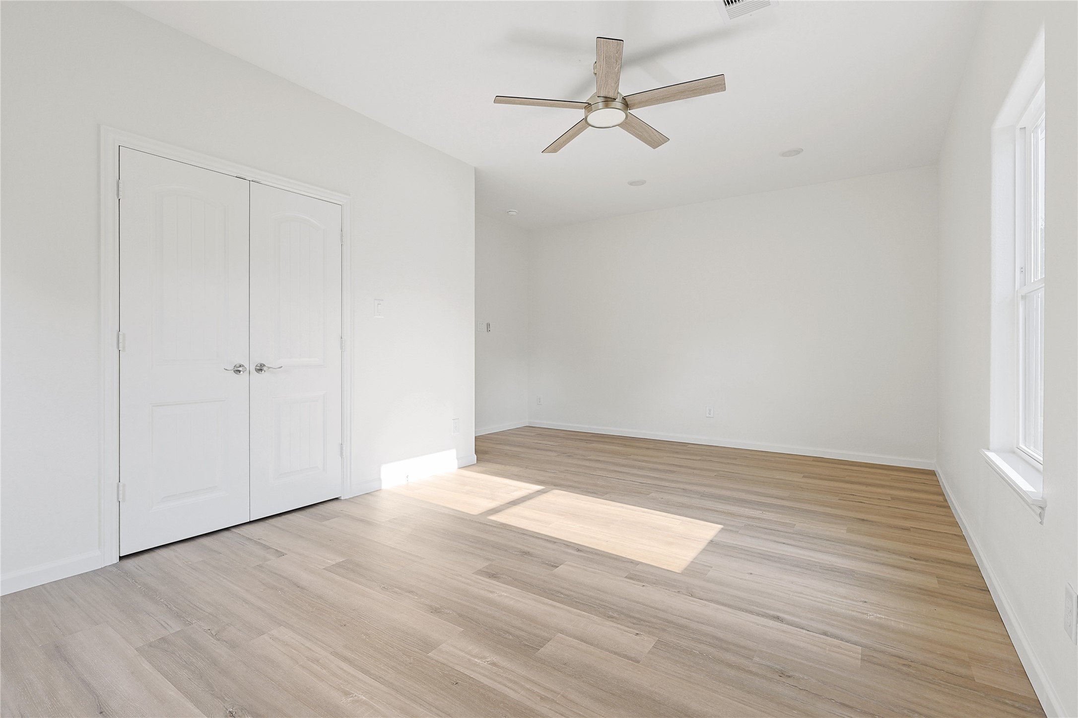 2317 Cedar Street Pearland, TX 77581 - Photo 24 of 33 an empty room with wooden floor ceiling fan and windows