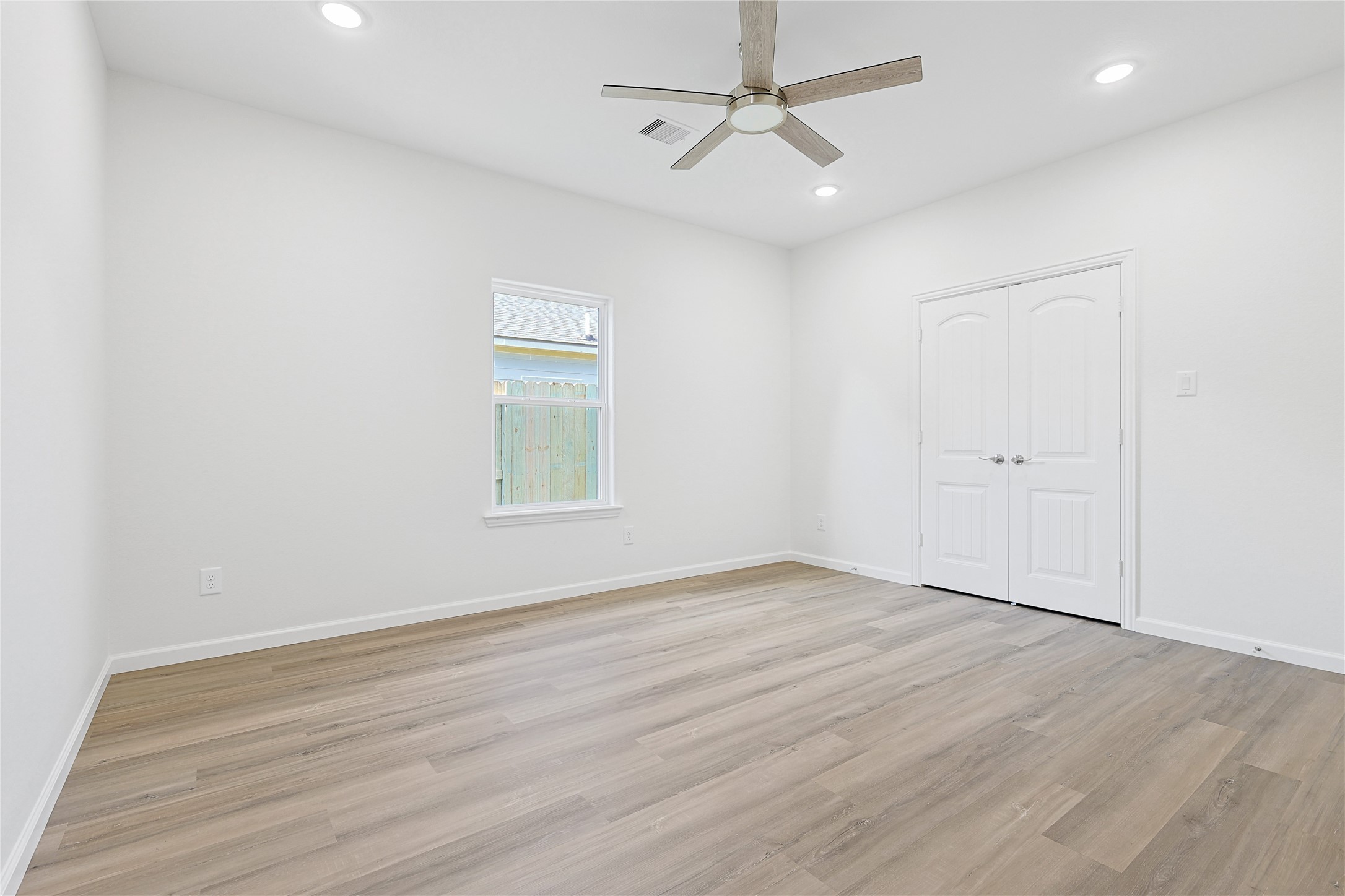 2317 Cedar Street Pearland, TX 77581 - Photo 25 of 33 an empty room with wooden floor ceiling fan and windows