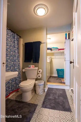 a room with water heater and wooden cabinets