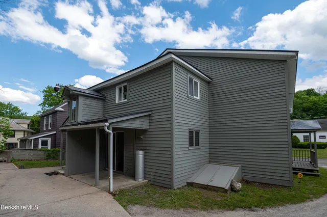 a view of house with a yard and potted plants