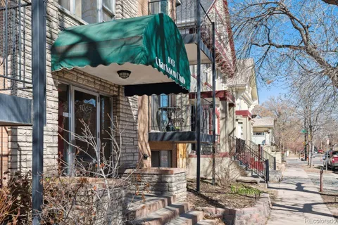 a brick building with a large tree in front of it