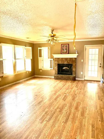 a view of an empty room with a fireplace and a window