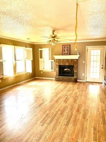a view of an empty room with a fireplace and a window