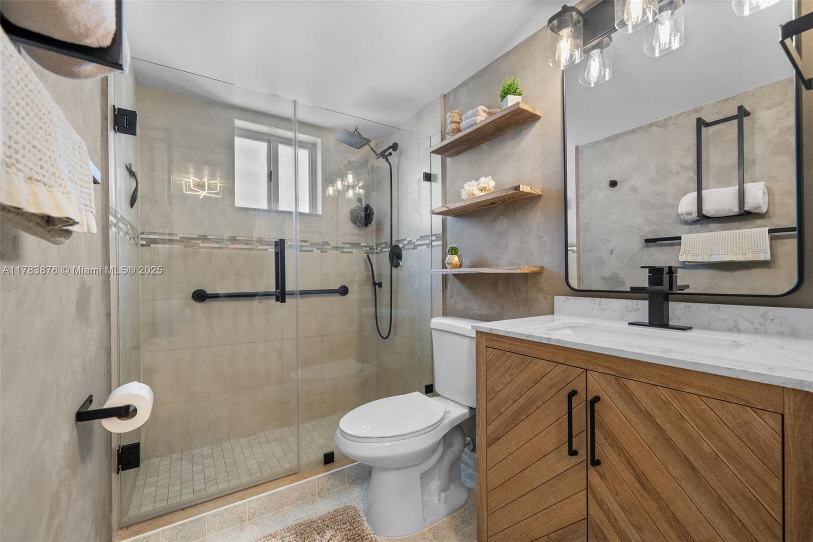 1401 Bay Road, Unit 506 Miami Beach, FL 33139 - Photo 17 of 28 a bathroom with a granite countertop toilet sink and mirror