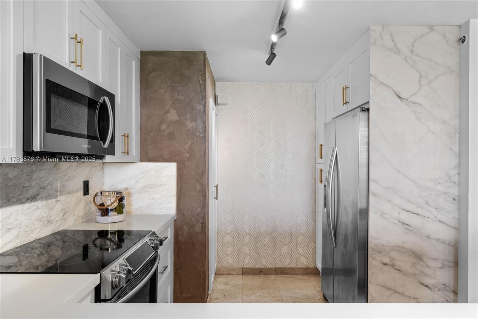 1401 Bay Road, Unit 506 Miami Beach, FL 33139 - Photo 9 of 28 a kitchen with stainless steel appliances granite countertop a refrigerator and a stove top oven