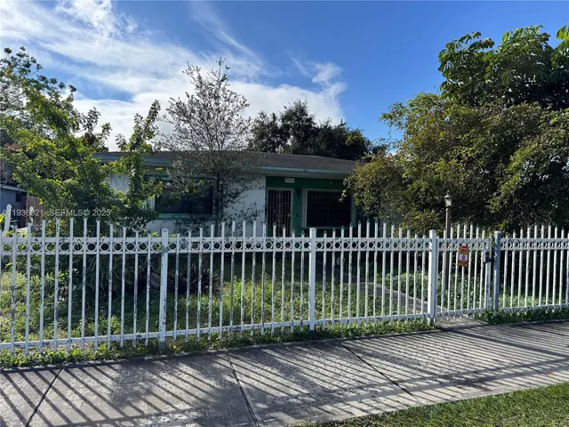a view of a house with a small yard and plants