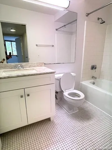 a bathroom with a granite countertop toilet sink and mirror