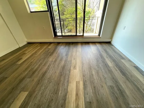 a view of a room with wooden floor and window