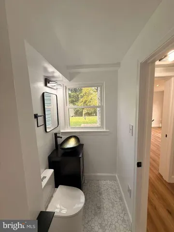 a bathroom with a toilet and a mirror