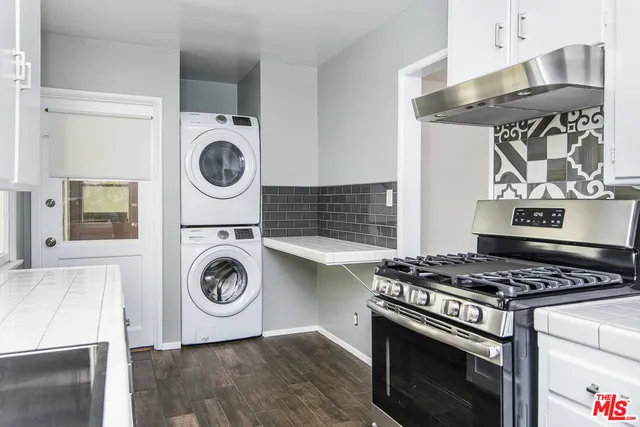 a kitchen with stove top oven and cabinets