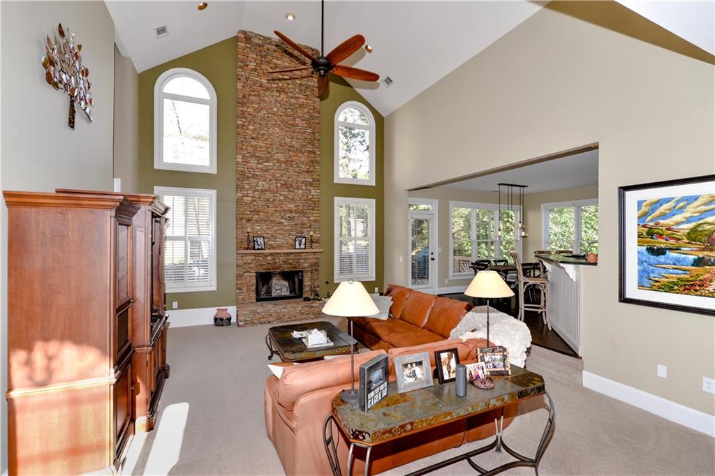 265 Windsor Gate Cove Northeast Atlanta, GA 30342 - Photo 14 of 62 a living room with furniture a fireplace and a flat screen tv