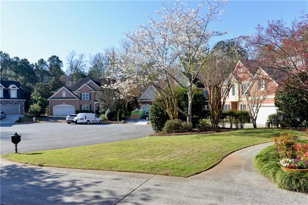 265 Windsor Gate Cove Northeast Atlanta, GA 30342 - Photo 3 of 62 a front view of a house with a yard and trees
