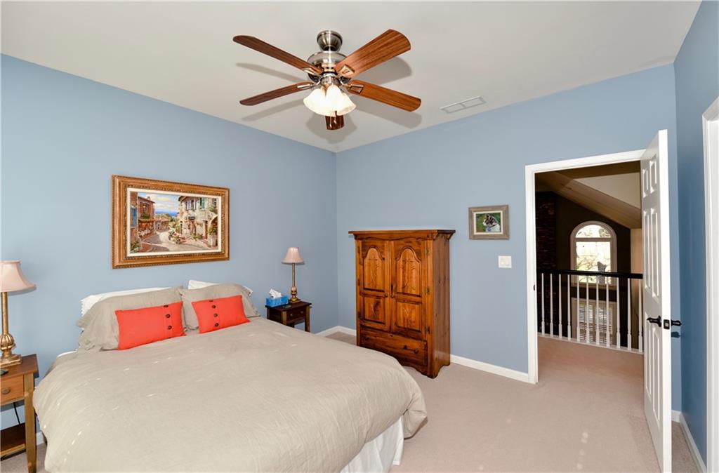 265 Windsor Gate Cove Northeast Atlanta, GA 30342 - Photo 39 of 62 a bedroom with a large bed and a chandelier