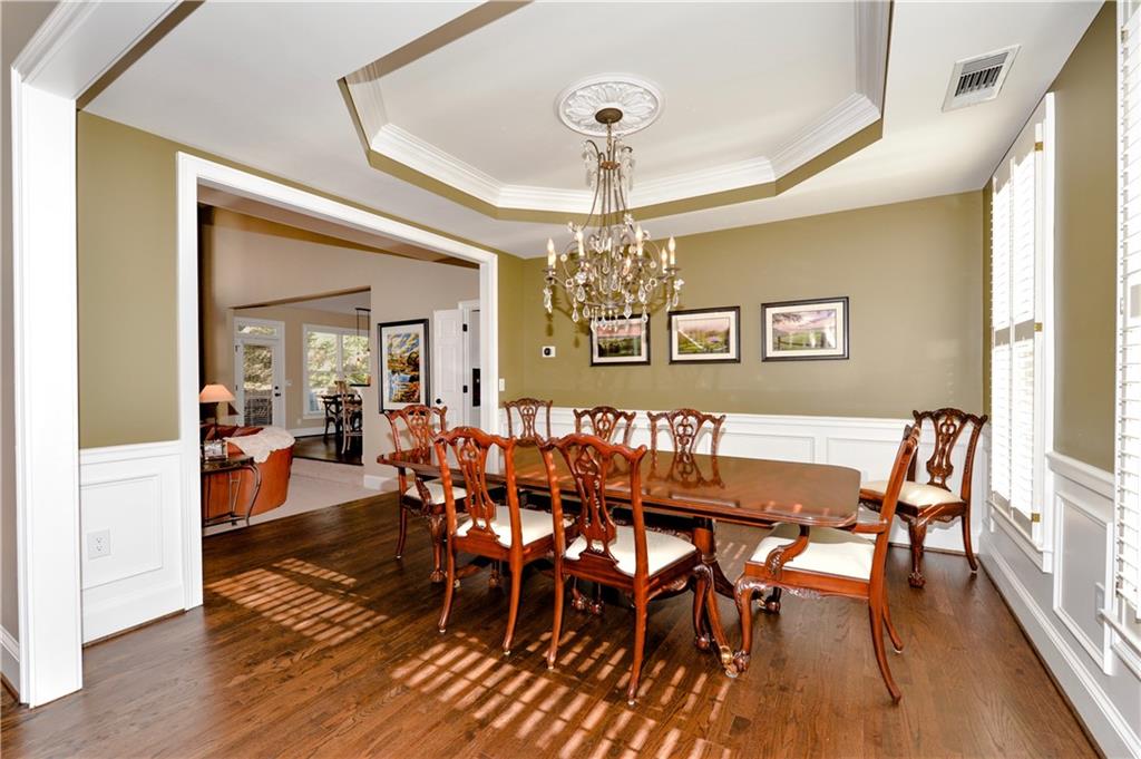 265 Windsor Gate Cove Northeast Atlanta, GA 30342 - Photo 6 of 62 a view of a dining room with furniture wooden floor and chandelier