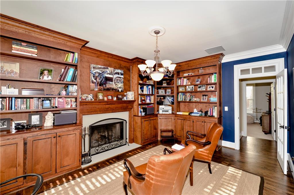 265 Windsor Gate Cove Northeast Atlanta, GA 30342 - Photo 8 of 62 a living room with furniture a fireplace and a book shelf