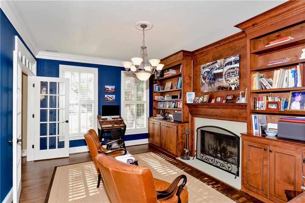 265 Windsor Gate Cove Northeast Atlanta, GA 30342 - Photo 9 of 62 a living room with furniture a fireplace and a book shelf