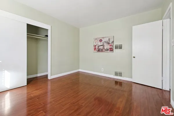 an empty room with wooden floor and closet
