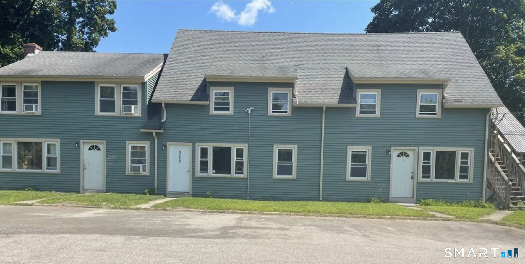 a view of a brick house with a yard next to a road