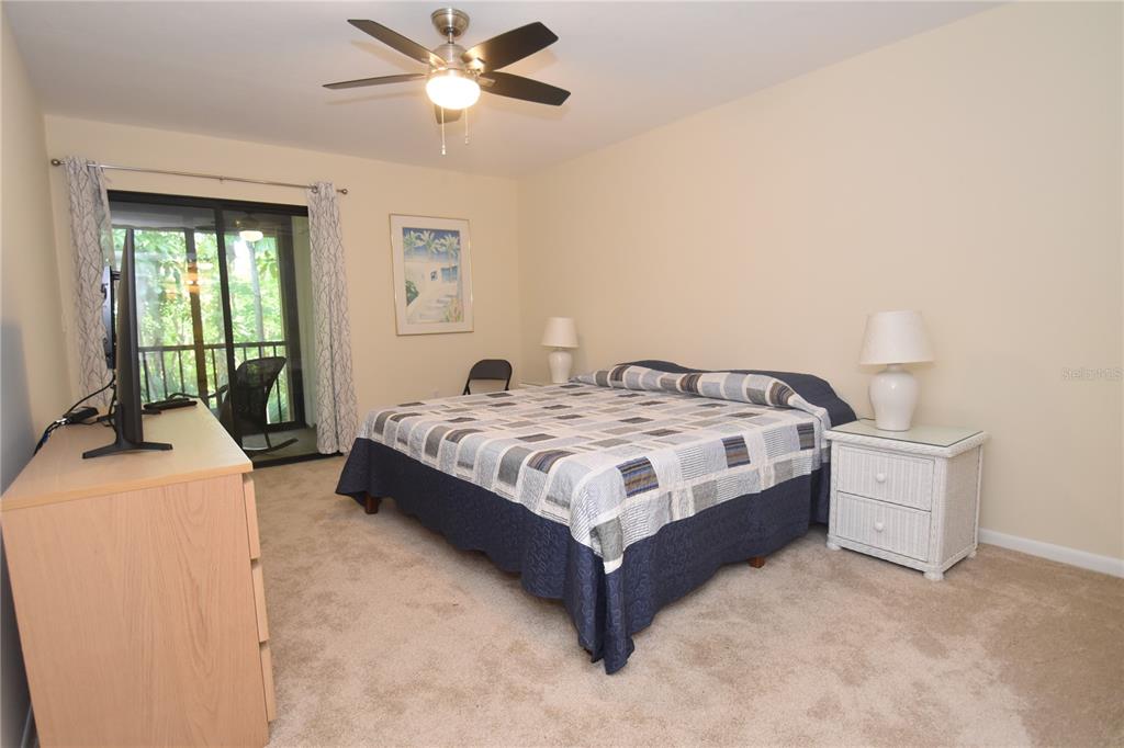 1677 Brookhouse Circle, Unit BR224 Sarasota, FL 34231 - Photo 7 of 12 a bedroom with a bed and a chandelier