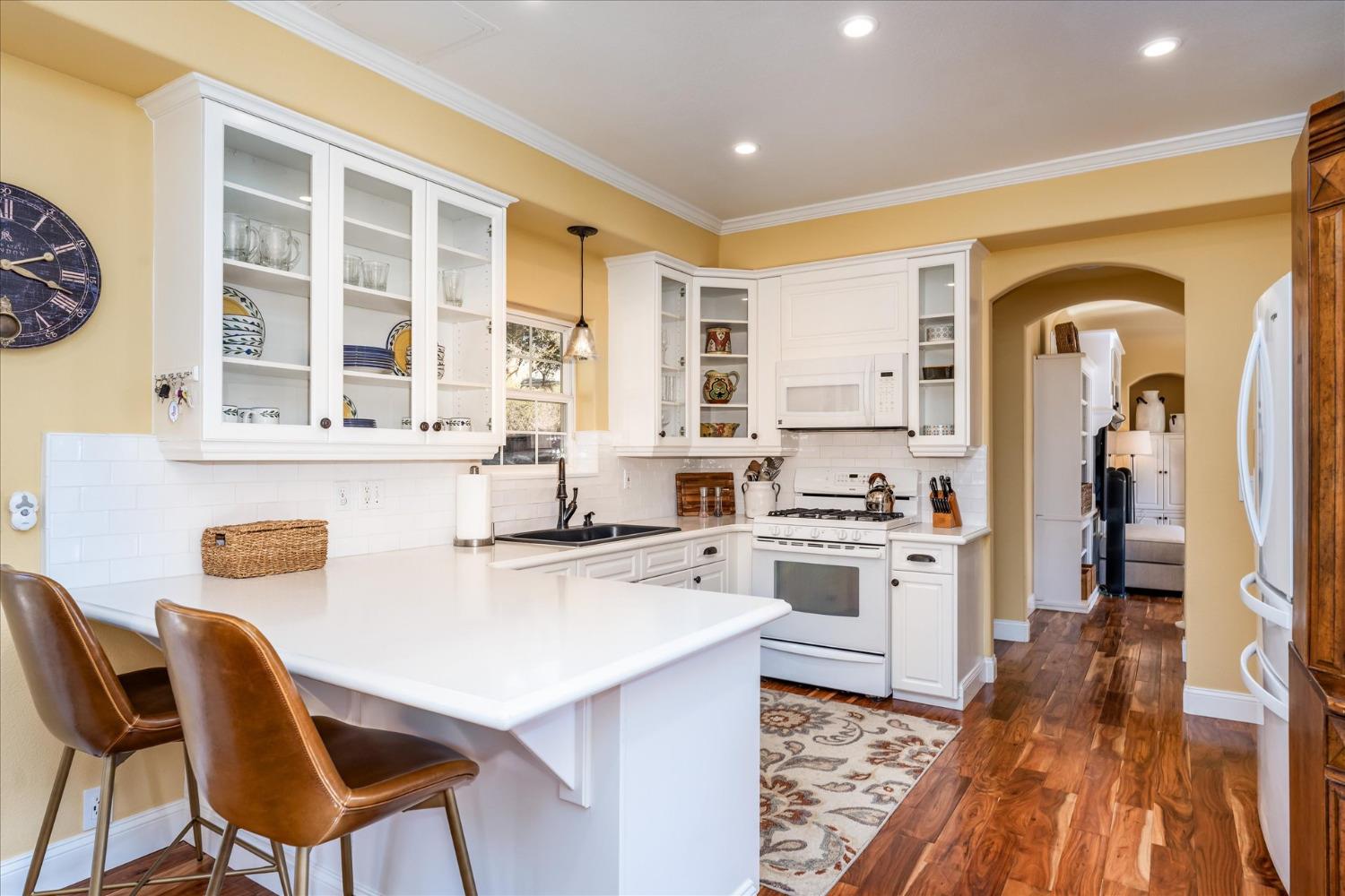28853 Limestone Way Coarsegold, CA 93614 - Photo 23 of 54 a kitchen with a stove a refrigerator and a dining table