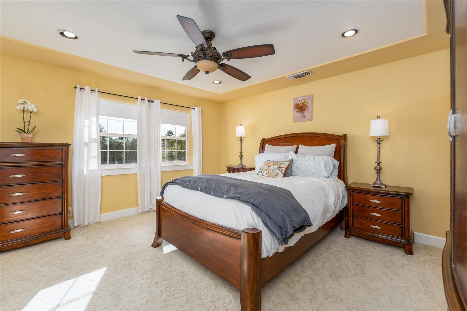 28853 Limestone Way Coarsegold, CA 93614 - Photo 37 of 54 a spacious bedroom with a bed and a chandelier