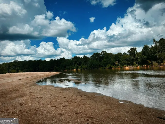 a view of a swimming pool with a table and chairs under an umbrella