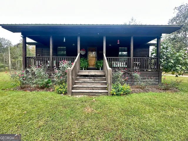 a view of a house with a yard and sitting area