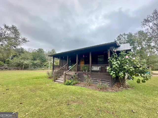a view of a house with backyard and sitting area