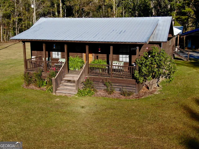 an aerial view of a house with a yard and lake view