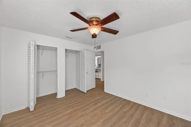 a view of room with wooden floor and ceiling fan