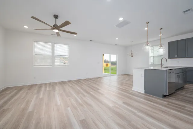 a view of an empty room and window and wooden floor