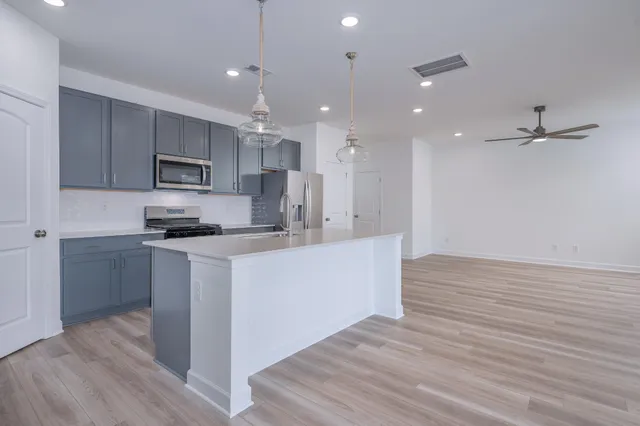 a kitchen with kitchen island a sink stainless steel appliances and cabinets