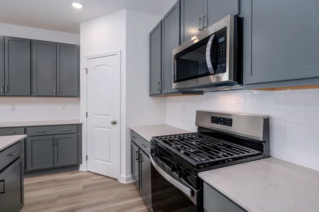 a kitchen with stainless steel appliances a microwave a sink and cabinets