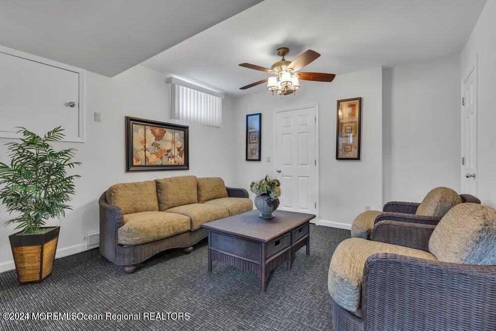 65 Cross Road Colts Neck, NJ 07722 - Photo 18 of 21 a living room with furniture potted plant and paintings on the wall